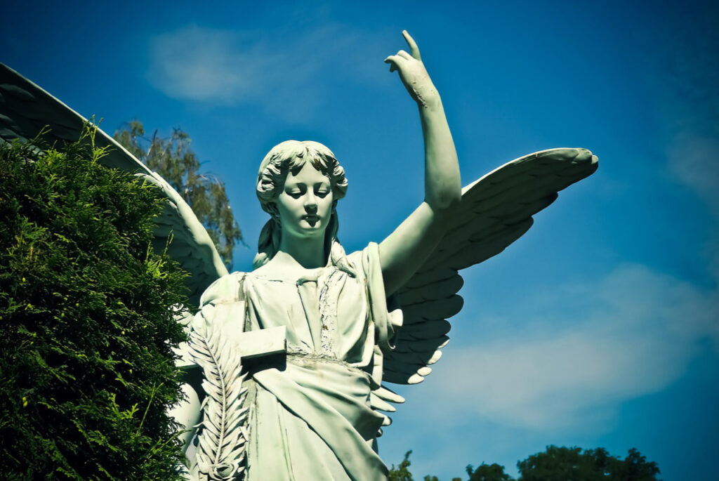 stone angel monument in the cemetery on a sunny day